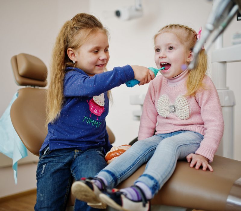 Two cutie little baby girls at dentist chair. Children dental.